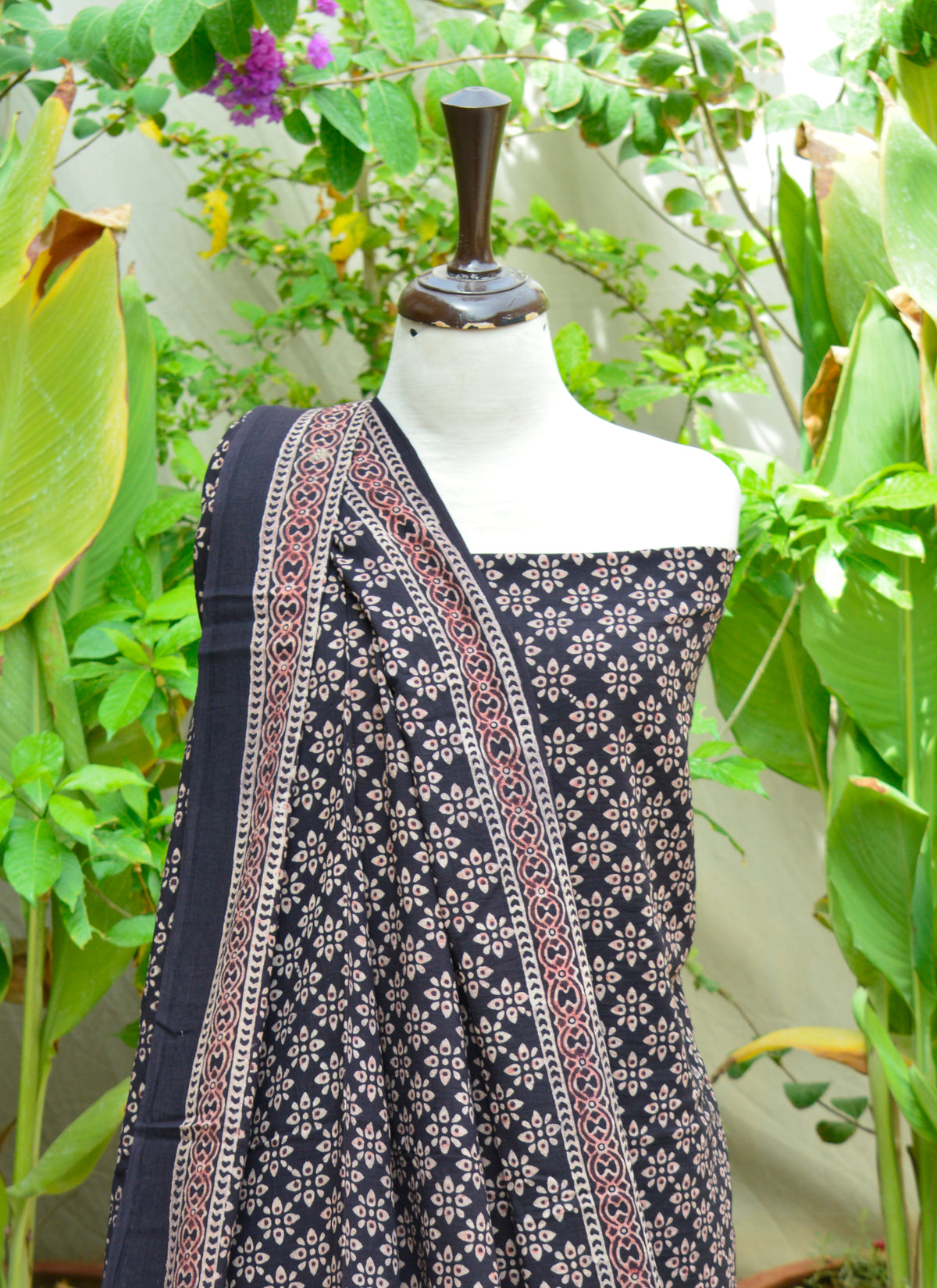 Traditional Ajrak design in black floral pattern, handcrafted with natural dyes on breathable lawn fabric.
