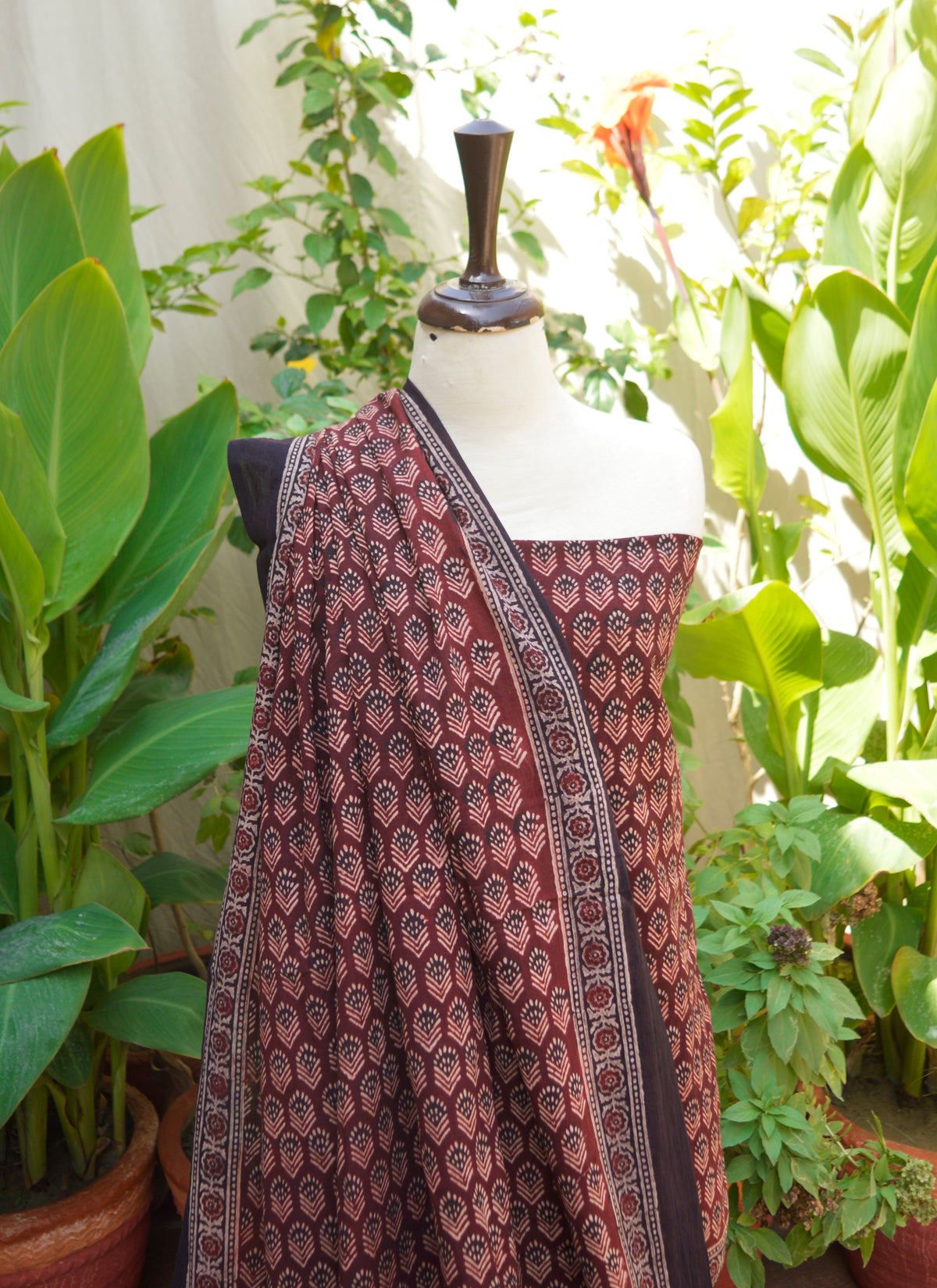 Handcrafted maroon Ajrak dress with intricate floral block printing, made from 100% pure lawn for breathable comfort and cultural elegance.