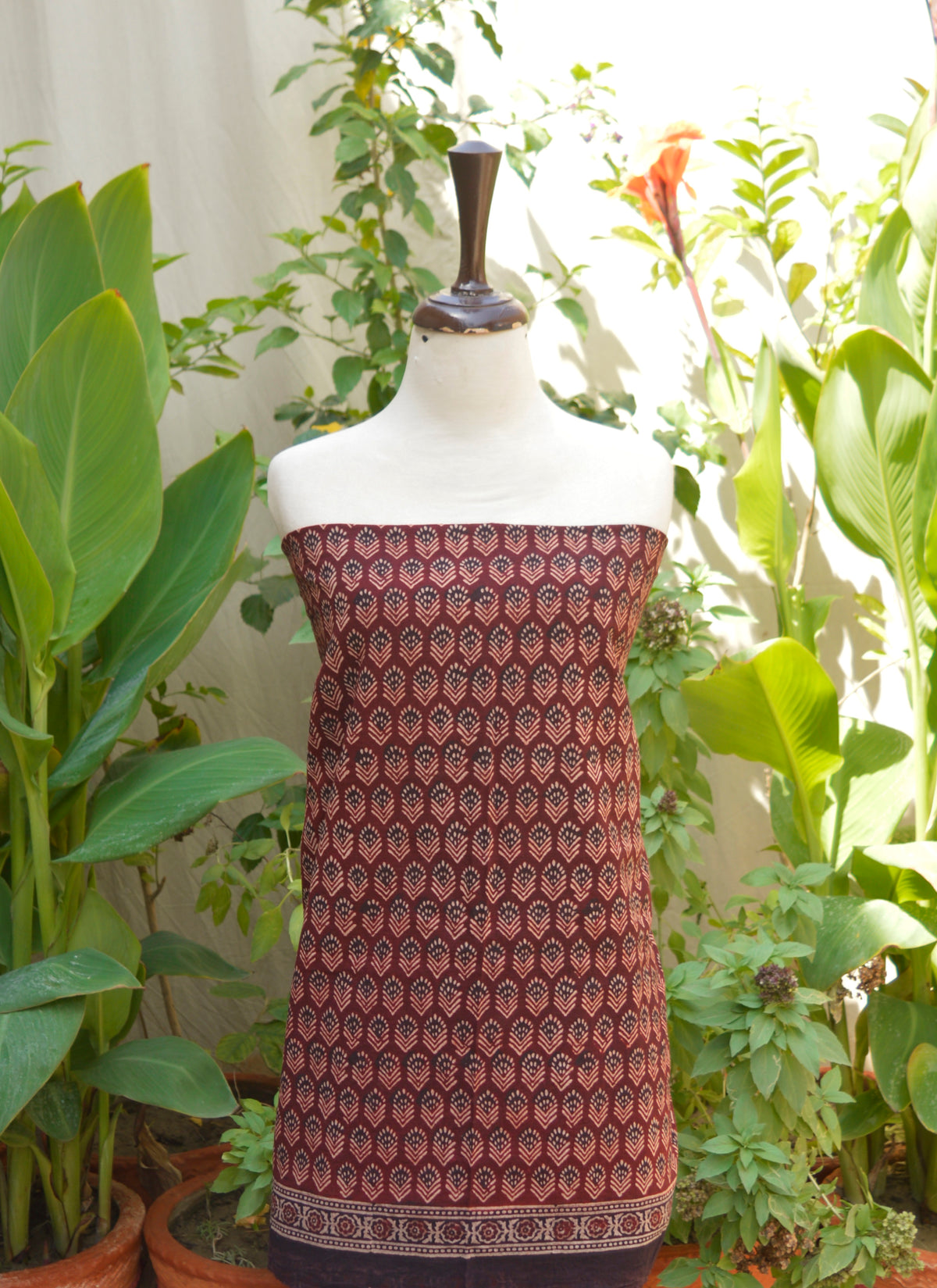 Elegant Ajrak maroon two-piece outfit with authentic Sindhi floral patterns, lightweight lawn fabric, and artisan-crafted shirt and dupatta set.