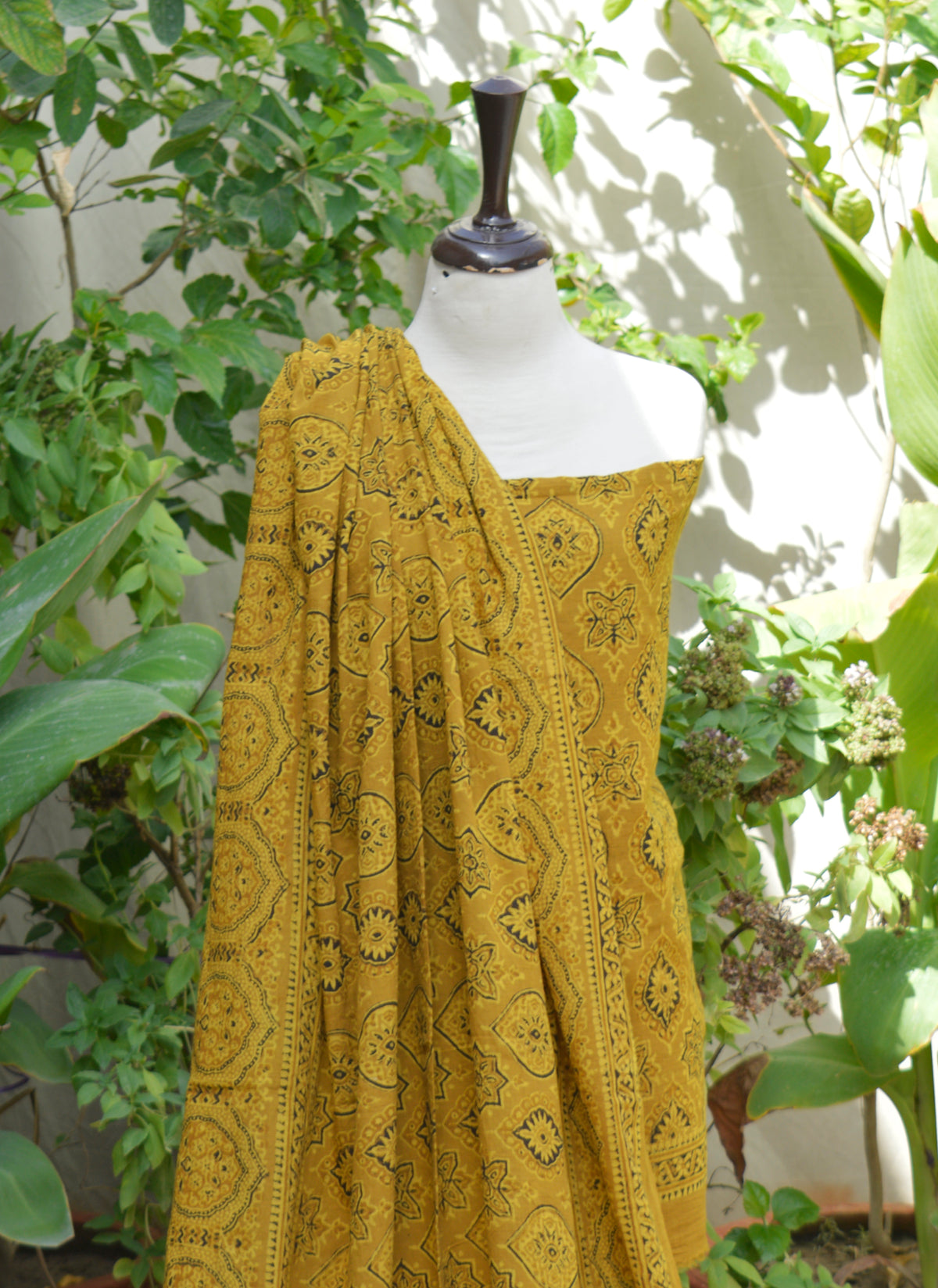 Unstitched lawn fabric Ajrak outfit in mustard color with traditional badam motifs handcrafted by artisans.