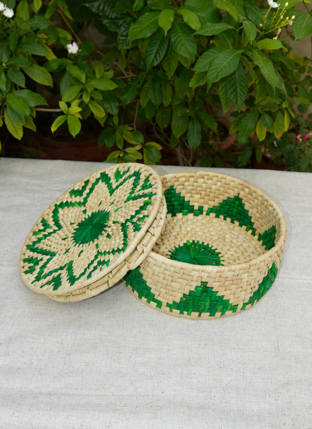 Eco-friendly handmade palm leaf roti basket with green woven geometric pattern