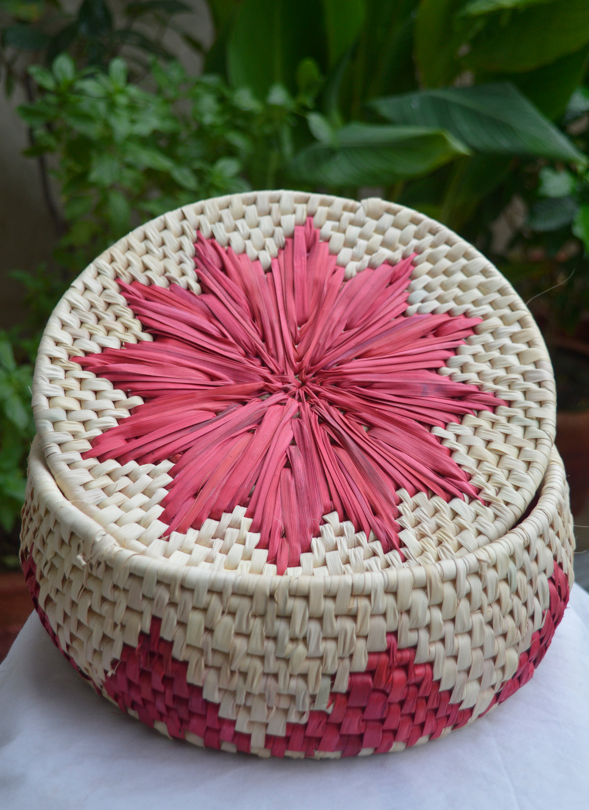 Hand woven palm leaf bread basket in red color, eco-friendly roti dan from Sindh.