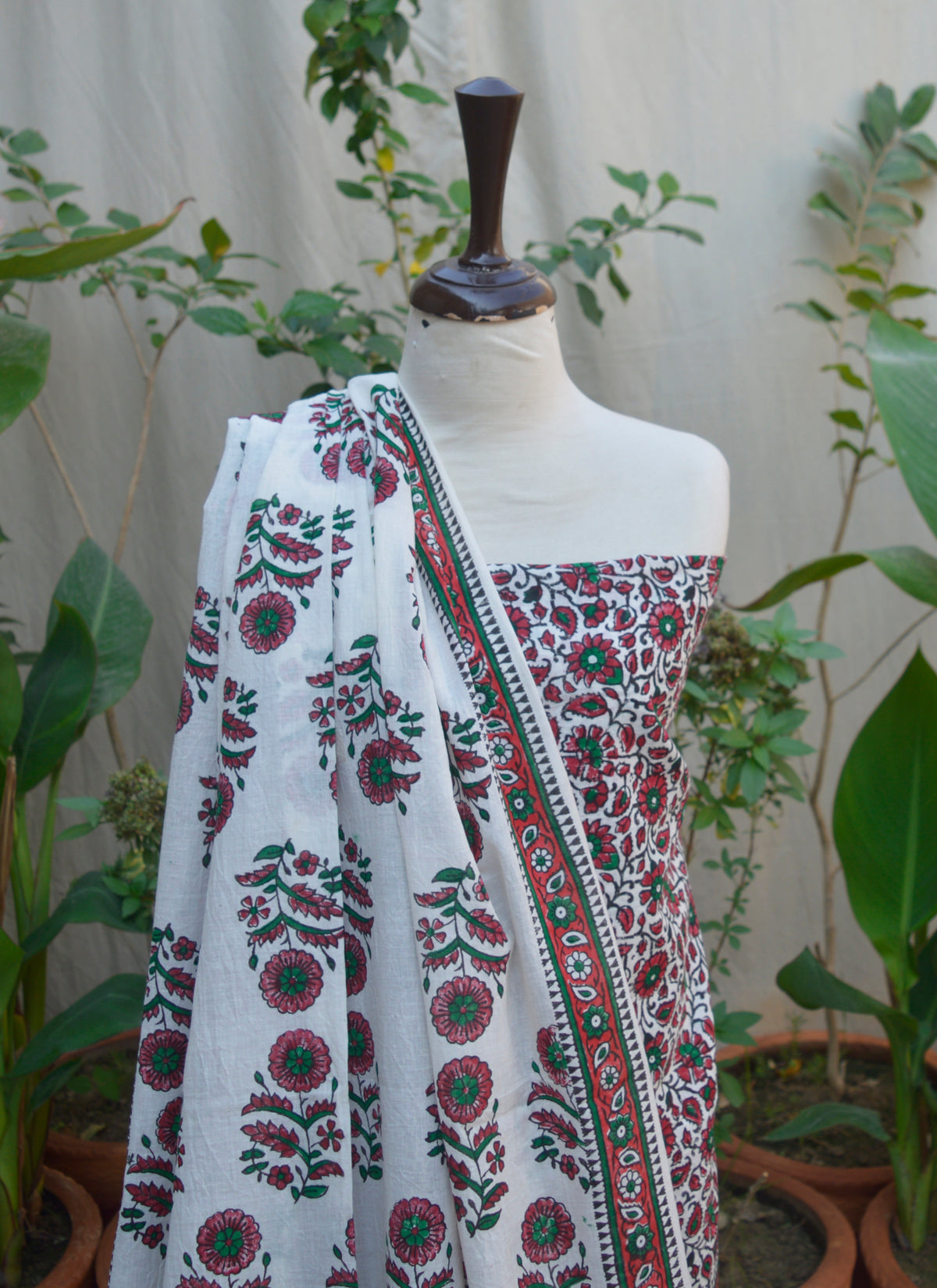 Close-up of Pinkish Red Daisy Flower Block Print on Soft White Lawn Fabric – Handcrafted Floral Design.