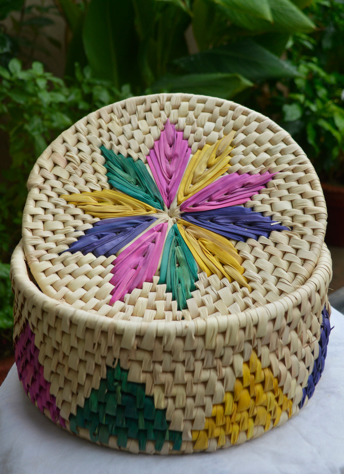 Hand-woven multi-color lotus flower bread basket made from natural datepalm leaves, eco-friendly roti dan crafted by Sindhi women artisans.