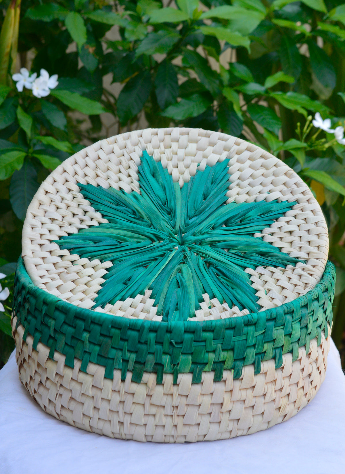 Hand-woven green flower bread basket made from natural date palm leaves with blue floral motif, sustainable roti dan from Sindhi women artisans.