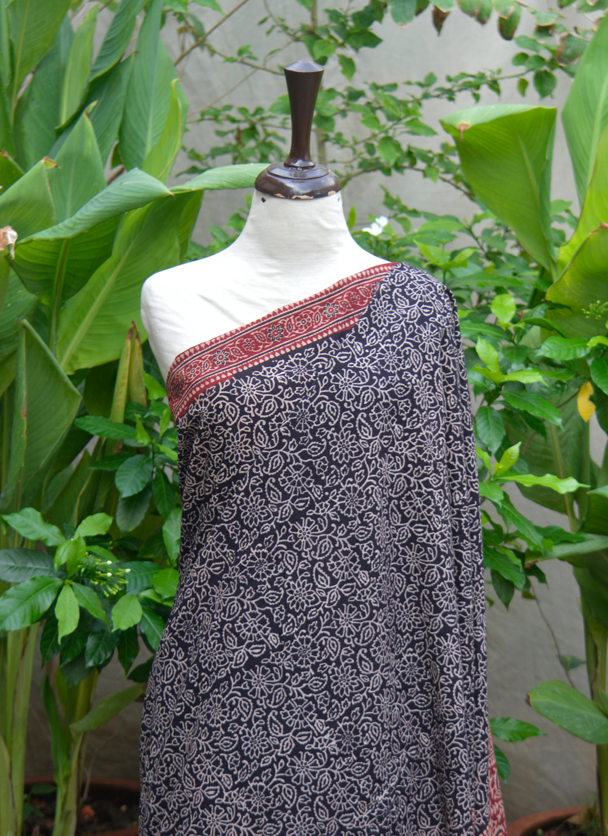 Floral bel design Ajrak saree printed with organic dyes on soft cotton, featuring matching blouse fabric.