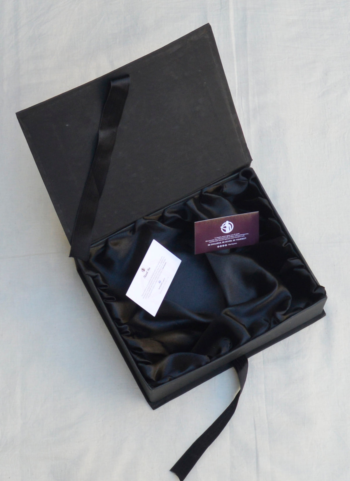 Black satin-lined gift box for clothing, accessories, and special occasion gifting.