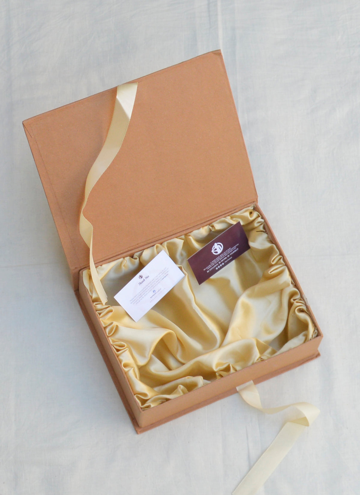 Elegant golden gift box with satin interior, ideal for clothing, accessories, and special occasion gifts.