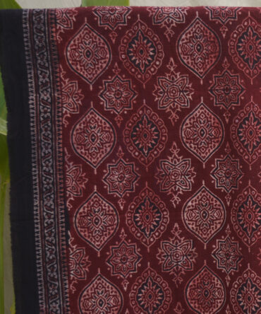 Ajrak Scarf around her neck, highlighting the elegance and traditional charm of the design.