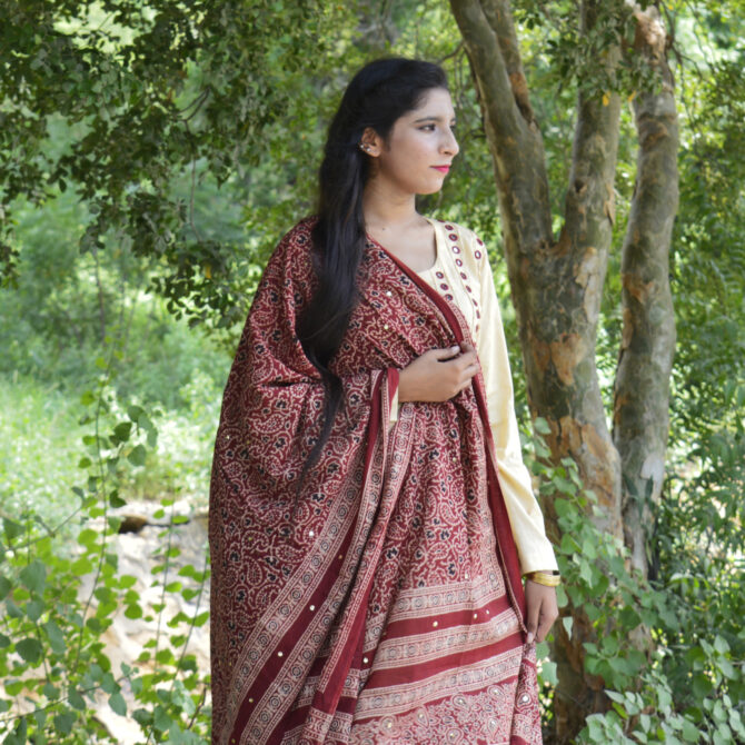 A model draping the Organic Dye Hand Block Printed Ajrak Odhni Chinar Leaf, highlighting its elegant design and luxurious Lawn cotton fabric.