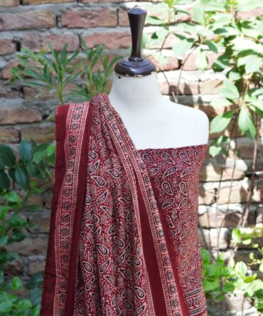 Close-up of the high-quality lawn cotton fabric of the Ajrak Anbi set, showcasing the rich maroonish red color and detailed hand block printing.