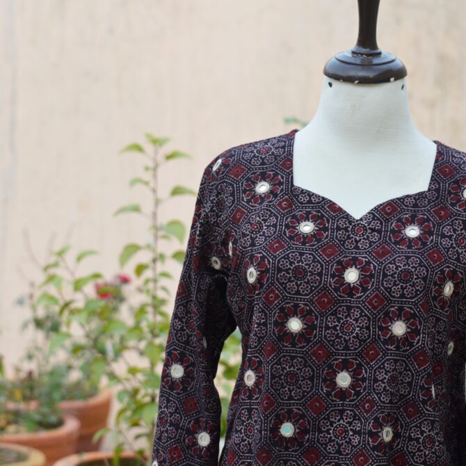 A close-up of the traditional hand block printing techniques used on the black Ajrak kurta, featuring intricate designs and organic dye coloring.