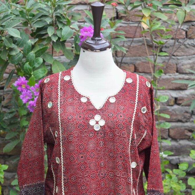 Close-up view of the intricate geometric and floral hand block-printed patterns on the deep red and black Ajrak Kurti, showcasing traditional craftsmanship.