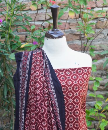 Ajrak Dress, Close-up of the hand block printed Ajrak floral jaal design in rich black and maroon, displaying the detailed craftsmanship on Lawn cotton fabric.