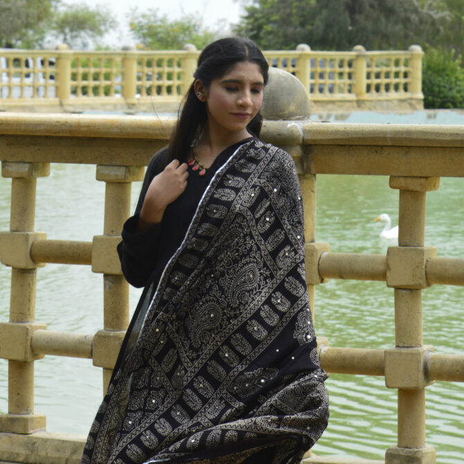 Model showcasing the versatile Black Ajrak Multi Blocks Odhni draped elegantly as a stylish shawl.