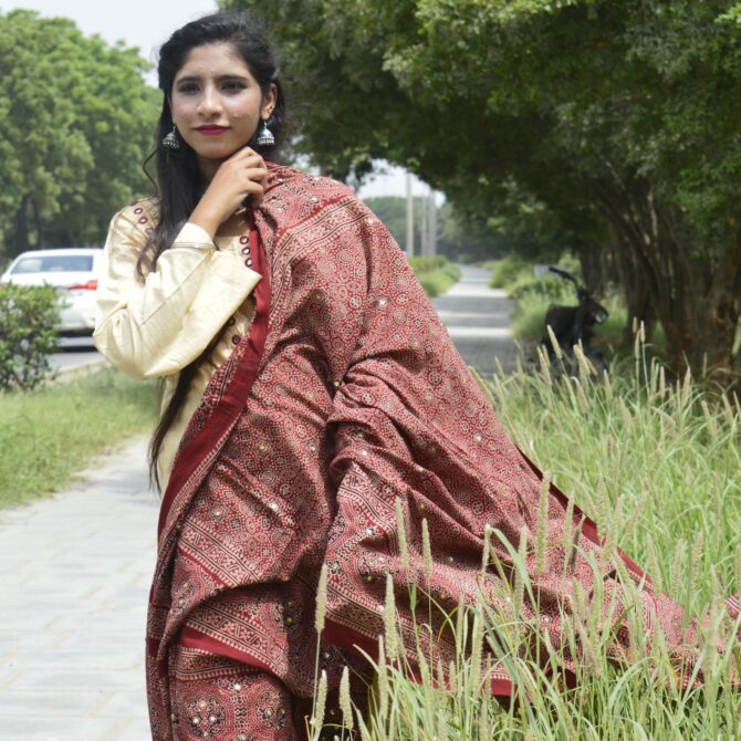 The Organic Dye Hand Block Printed Ajrak Odhni Sassui laid flat, displaying its intricate patterns in deep Mehroonish Red against a soft, breathable fabric.