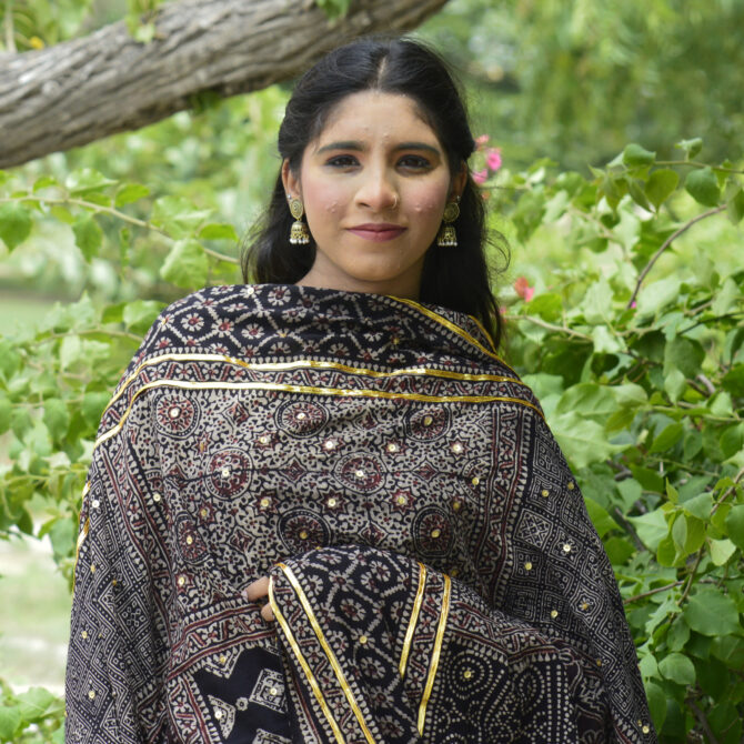 Close-up view of the hand block printing technique on the Ajrak Chaadar, highlighting the detailed patterns and rich organic black dye.