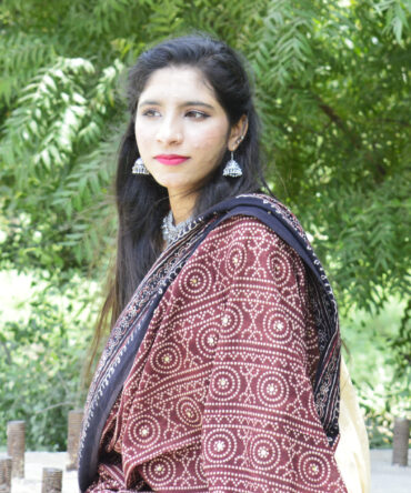 Handcrafted Ajrak Chunri Odhni in a rich mehroonish red, featuring eye-catching geometric and chunri motifs. Made from lightweight lawn cotton and dyed with organic materials, this odhni blends timeless tradition with modern eco-friendly fashion, perfect for versatile styling.