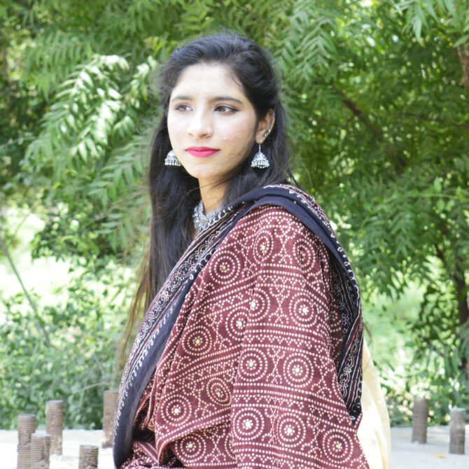 Handcrafted Ajrak Chunri Odhni in a rich mehroonish red, featuring eye-catching geometric and chunri motifs. Made from lightweight lawn cotton and dyed with organic materials, this odhni blends timeless tradition with modern eco-friendly fashion, perfect for versatile styling.