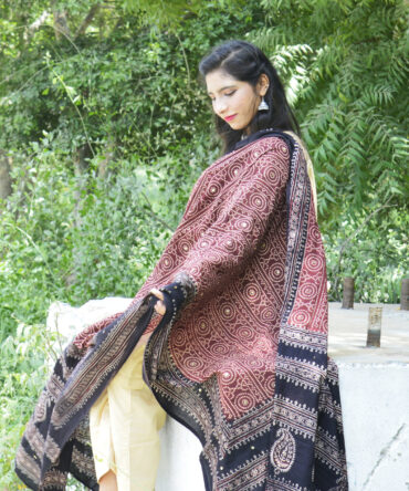 A stunning Organic Dye Hand Block Printed Ajrak Chunri Odhni with intricate red geometric and chunri patterns. The fabric is soft, breathable lawn cotton, measuring 2.5 meters long and 44 inches wide. Its traditional hand-printed design, crafted using eco-friendly dyes, makes it an elegant and sustainable fashion choice.