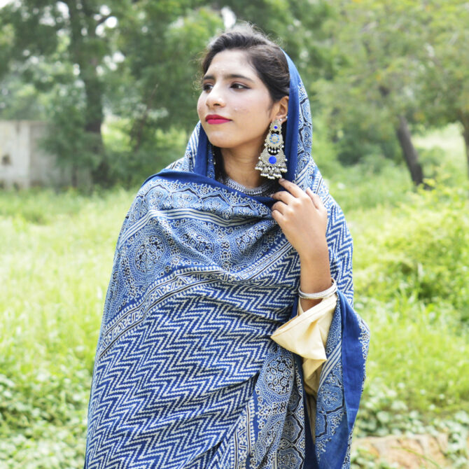 Artisan-crafted Organic Dye Hand Block Printed Ajrak Zigzag Odhni in deep indigo, highlighting exquisite floral and geometric patterns in mehroonish red. Measuring 2.5 meters in length and 44 inches in width, this lightweight Lawn cotton odhni offers versatile styling options.