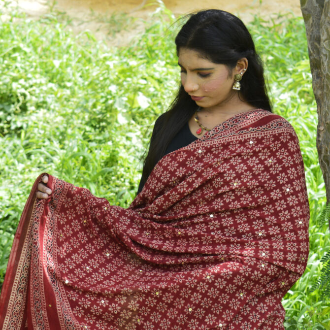 Close-up view of the intricate hand block printing on the Organic Dye Ajrak Odhni Floral, featuring floral motifs and shimmering sitara sequences.