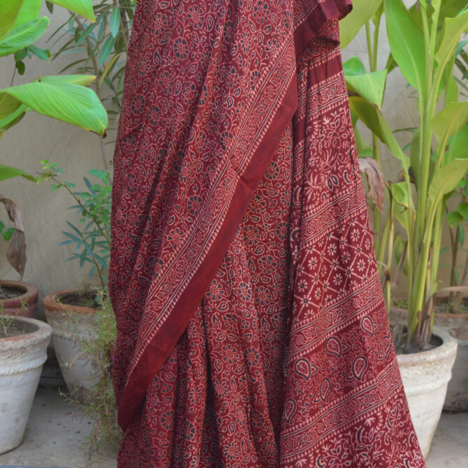 The Ethnic Ajrak Saree in maroon displayed in various draping styles, illustrating its versatility for both casual and formal occasions.