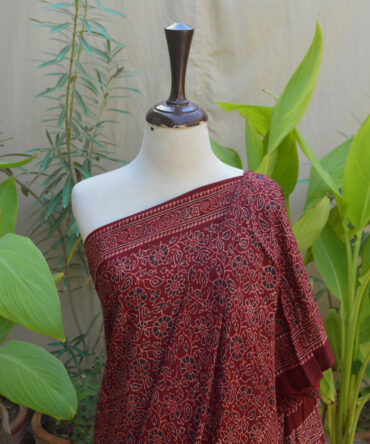 Detailed close-up of the maroon Ethnic Ajrak Saree displaying vibrant colors and traditional patterns, highlighting the craftsmanship involved in its creation.