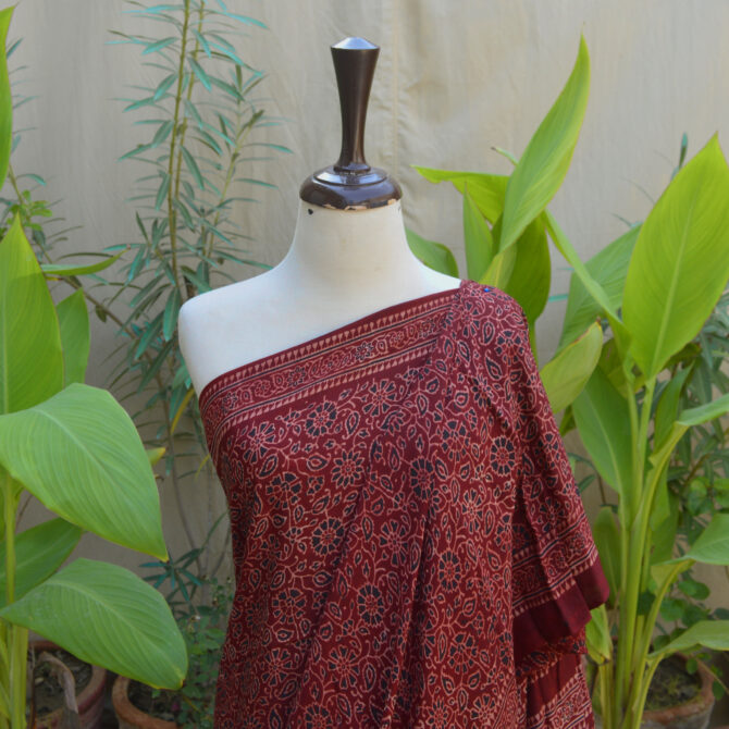 Detailed close-up of the maroon Ethnic Ajrak Saree displaying vibrant colors and traditional patterns, highlighting the craftsmanship involved in its creation.