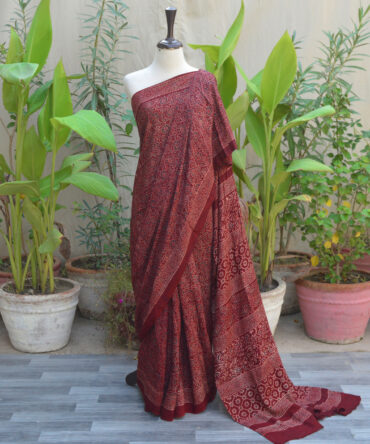 A beautiful Ethnic Ajrak Saree in maroon featuring intricate hand block printing, showcasing geometric and floral designs crafted by skilled artisans.