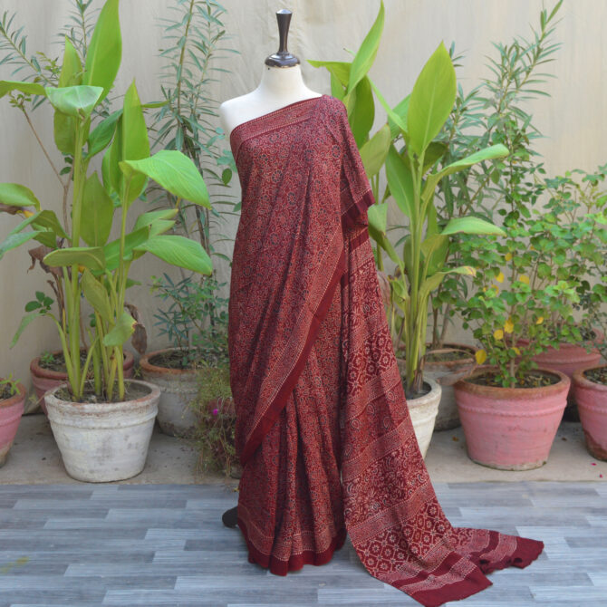 A beautiful Ethnic Ajrak Saree in maroon featuring intricate hand block printing, showcasing geometric and floral designs crafted by skilled artisans.