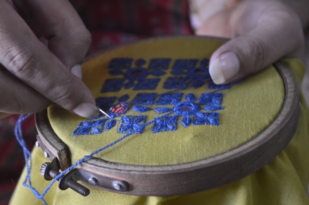 Close-up view of intricate Sindhi hand embroidery, featuring geometric and floral patterns.