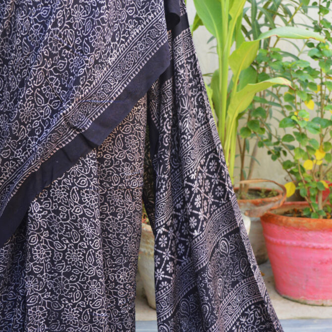 the black Ethnic Ajrak Saree, highlighting its flowing Modal Silk fabric and intricate block print designs for a modern, heritage-inspired look.