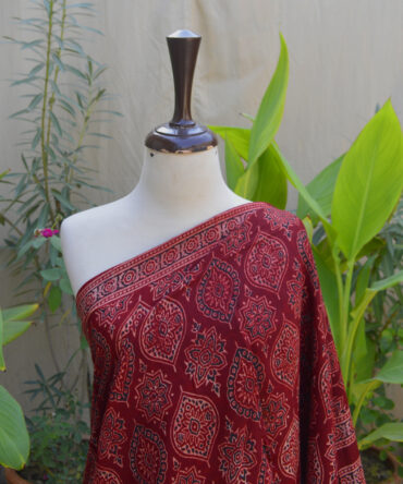 Close-up of the Ethnic Ajrak Saree in deep Reddish Maroon, highlighting traditional Ajrak hand block printing with eco-friendly organic dyes, showcasing detailed craftsmanship.