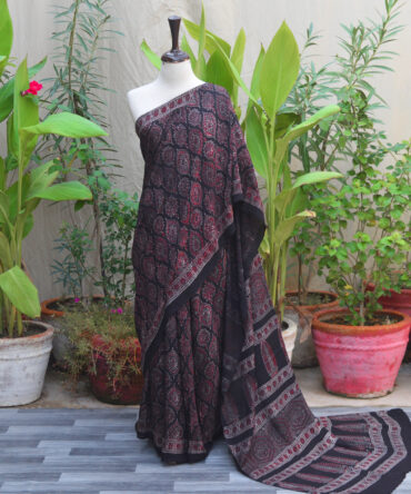 Ethnic Ajrak Saree Sundaree, a handcrafted saree featuring traditional Ajrak print, blending rich cultural heritage with contemporary style. The saree is elegantly draped, showcasing detailed artisan work and intricate patterns that reflect timeless craftsmanship.