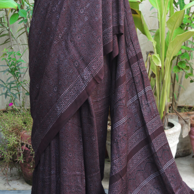 Close-up of Black Raspberry Ajrak saree, highlighting the deep hues and detailed block printing on soft silk cotton fabric.