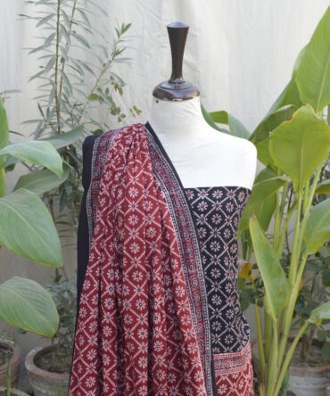 Organic Dye Hand Block Printed Ajrak Dress - Two-Piece Unstitched Set, featuring a floral and geometric design in black and red on luxurious Leelan fabric, displayed with a folded dupatta.